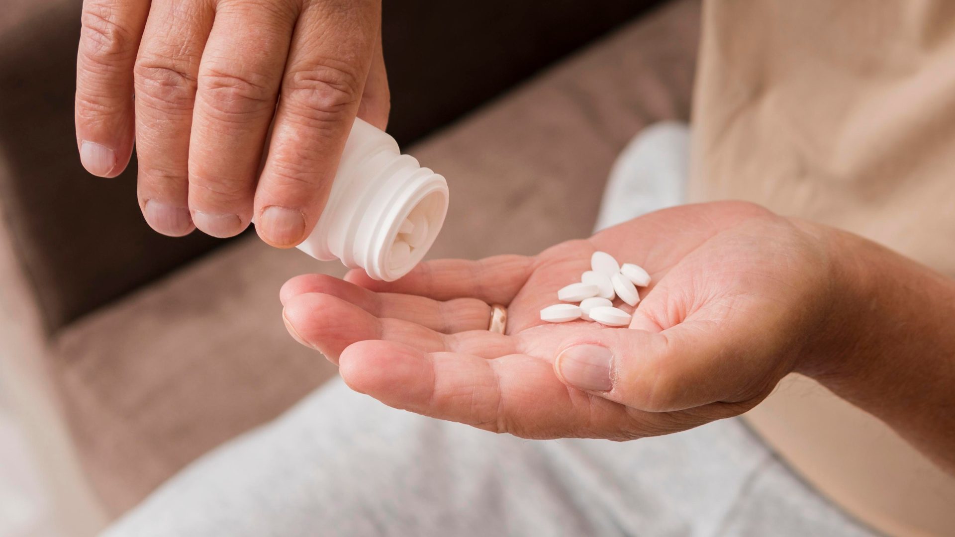 Hand pouring white benzodiazepine tablets into an open palm