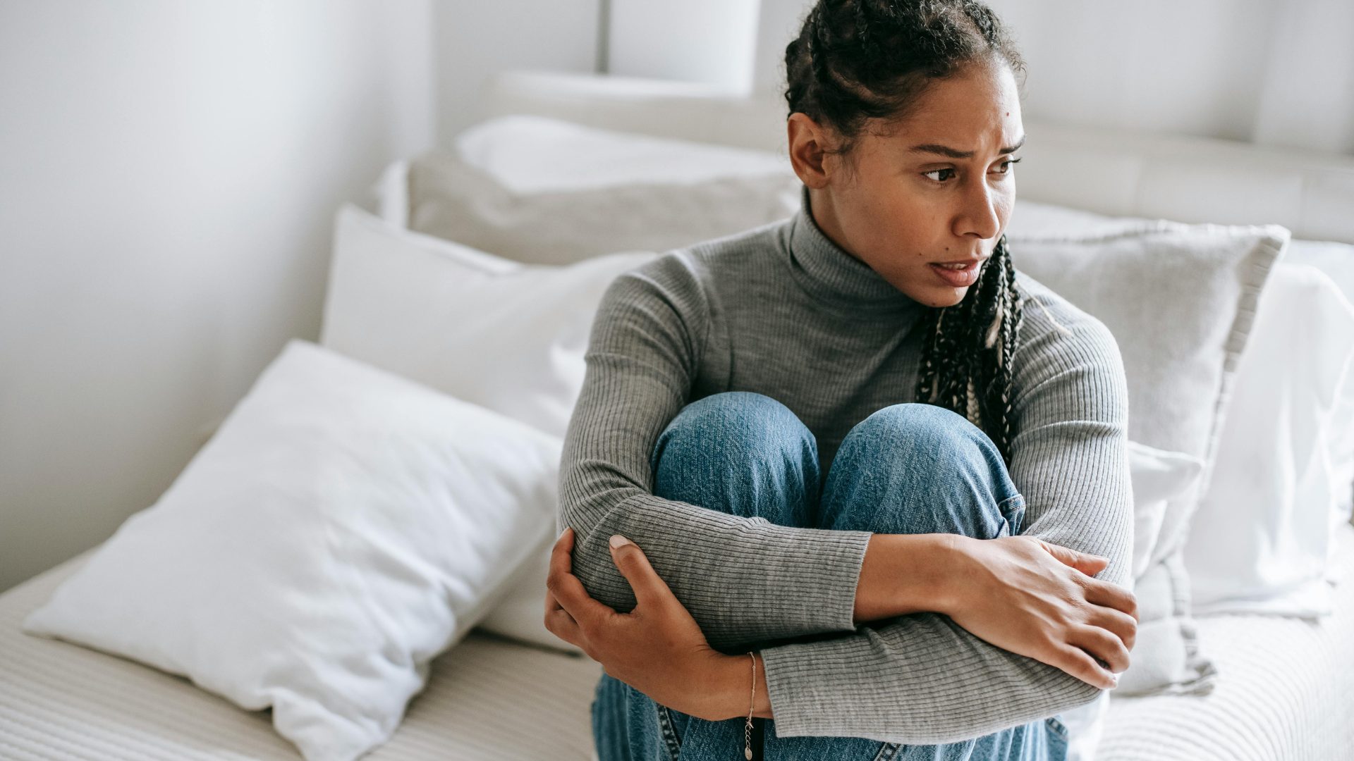 Woman sitting on her bed working through lingering benzodiazepine withdrawal symptoms